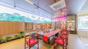 A modern bar area with wooden furniture, shelves with various items, and a large mural on the wall. - Youpin Hotel (Linyi)