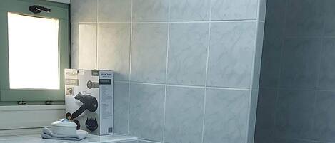 Un baño con lavamanos, ducha e inodoro.