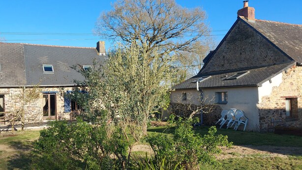 A stone farmhouse with a sloped roof, a small garden, and a clear blue sky. - Mézon Maëlle, ideal for families and friends (Teillay)