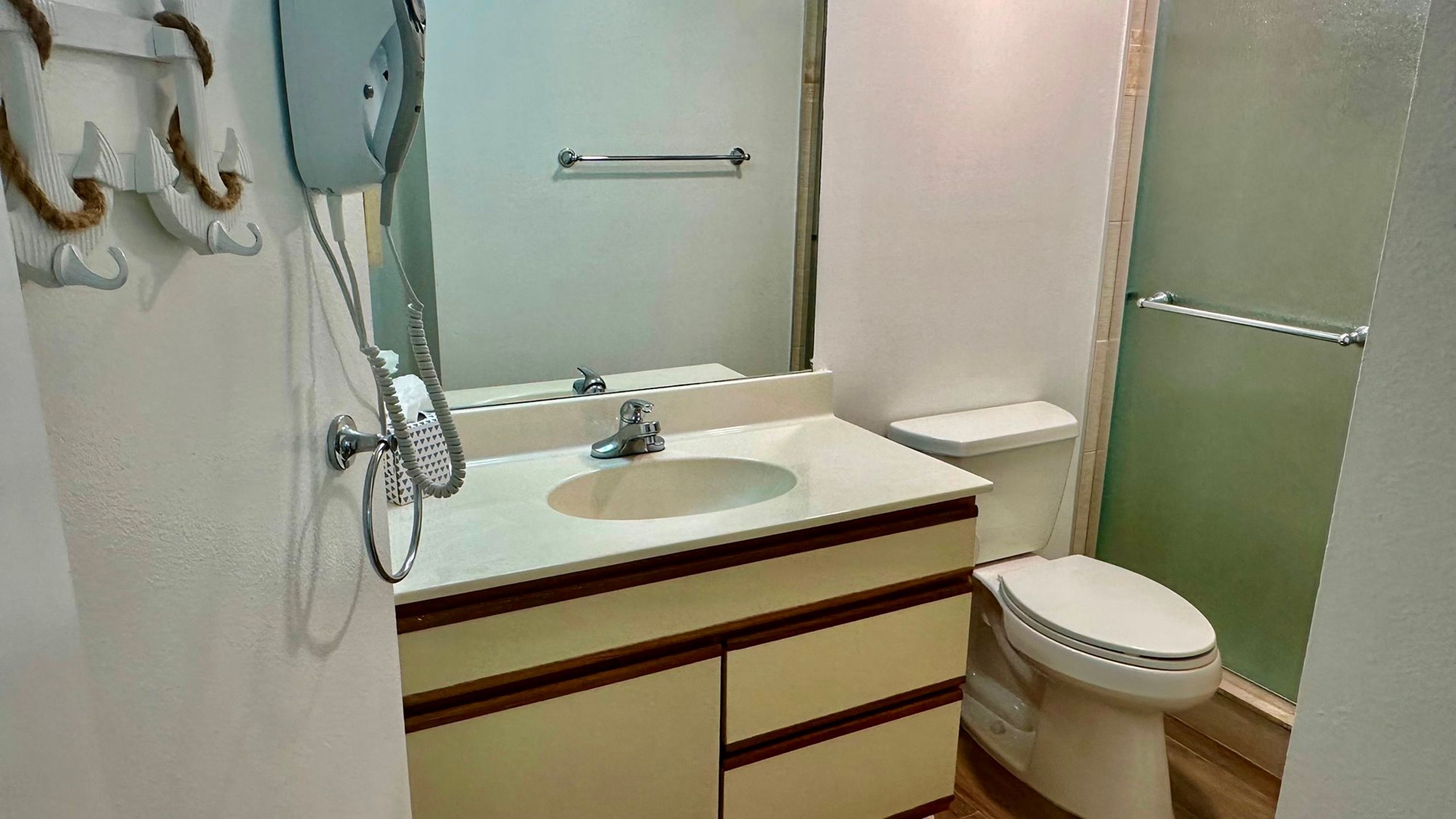 A bathroom with a sink, toilet, and a glass shower enclosure.