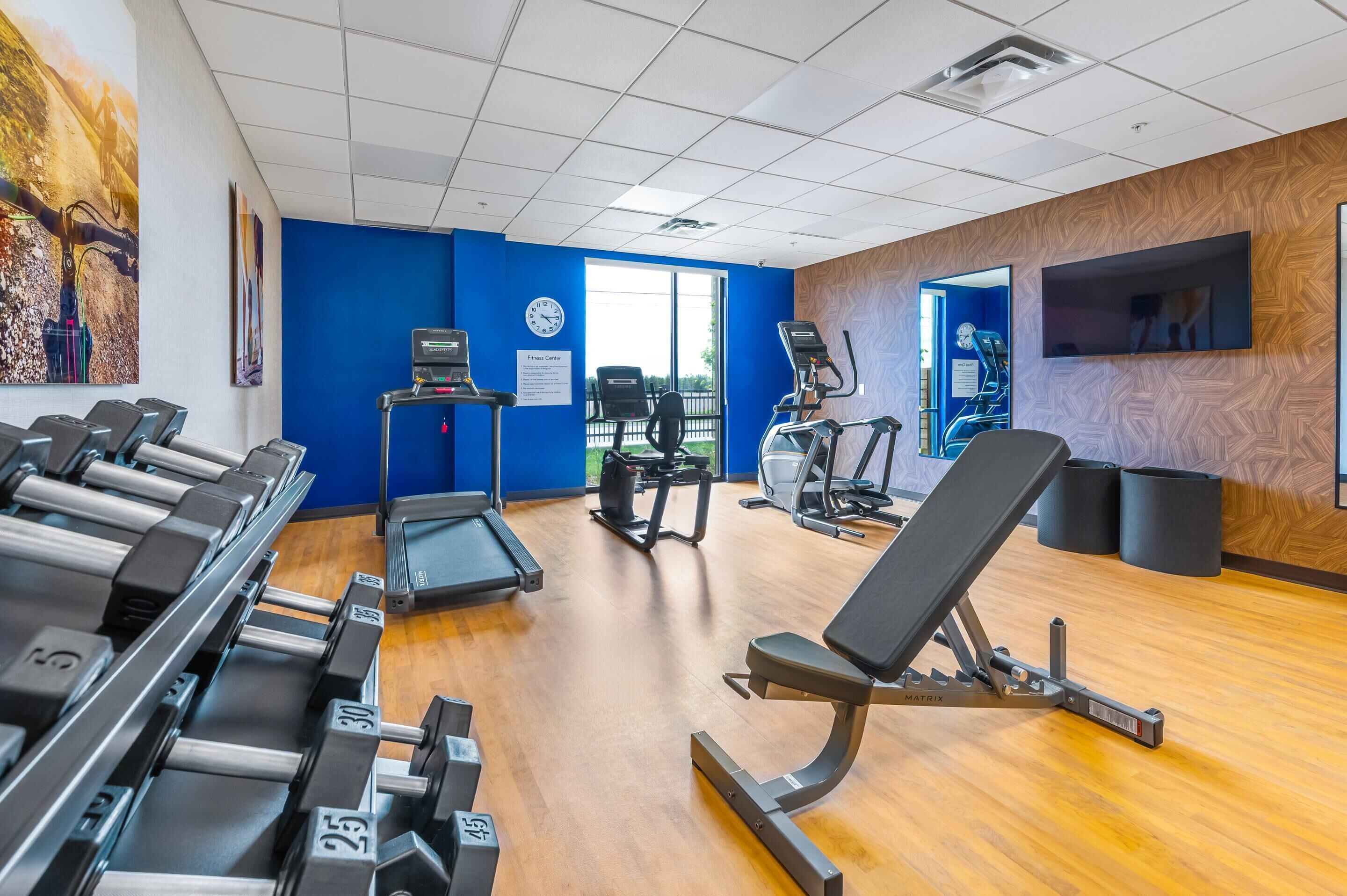 A gym with treadmills, a stationary bike, and a weight bench.