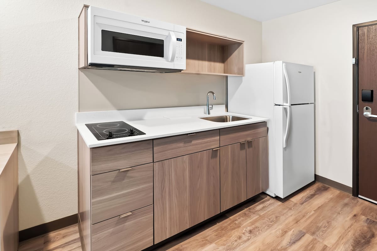 A compact kitchen with a microwave, sink, and refrigerator.