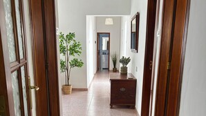 Ein Flur mit Holztüren, einem Blumentopf und einem Schmuckkästchen.