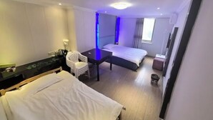 A hotel room with two beds, a desk, a chair, and a small table. - Shuanggang Hotel (Shanghai)
