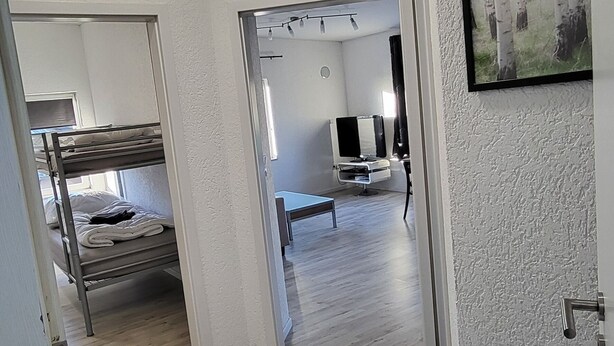A hallway with a bunk bed, a desk, and a chair in a room. - Vacation apartment / fitter's apartment / short-term rental (Schönborn)