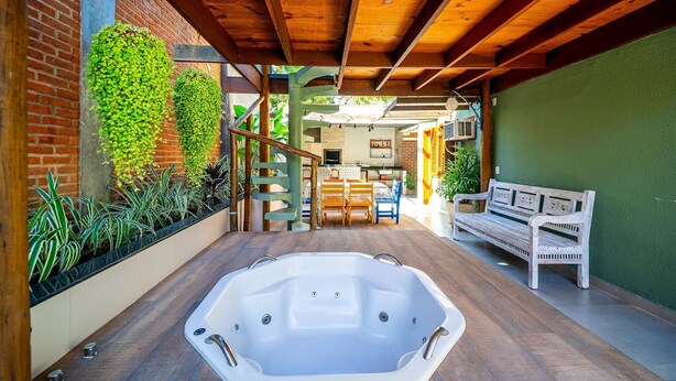 Un espace bien-être comprenant un jacuzzi, une terrasse en bois et un mur en briques.