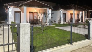 Uma casa de dois andares com um gramado bem cuidado e uma cerca de metal.