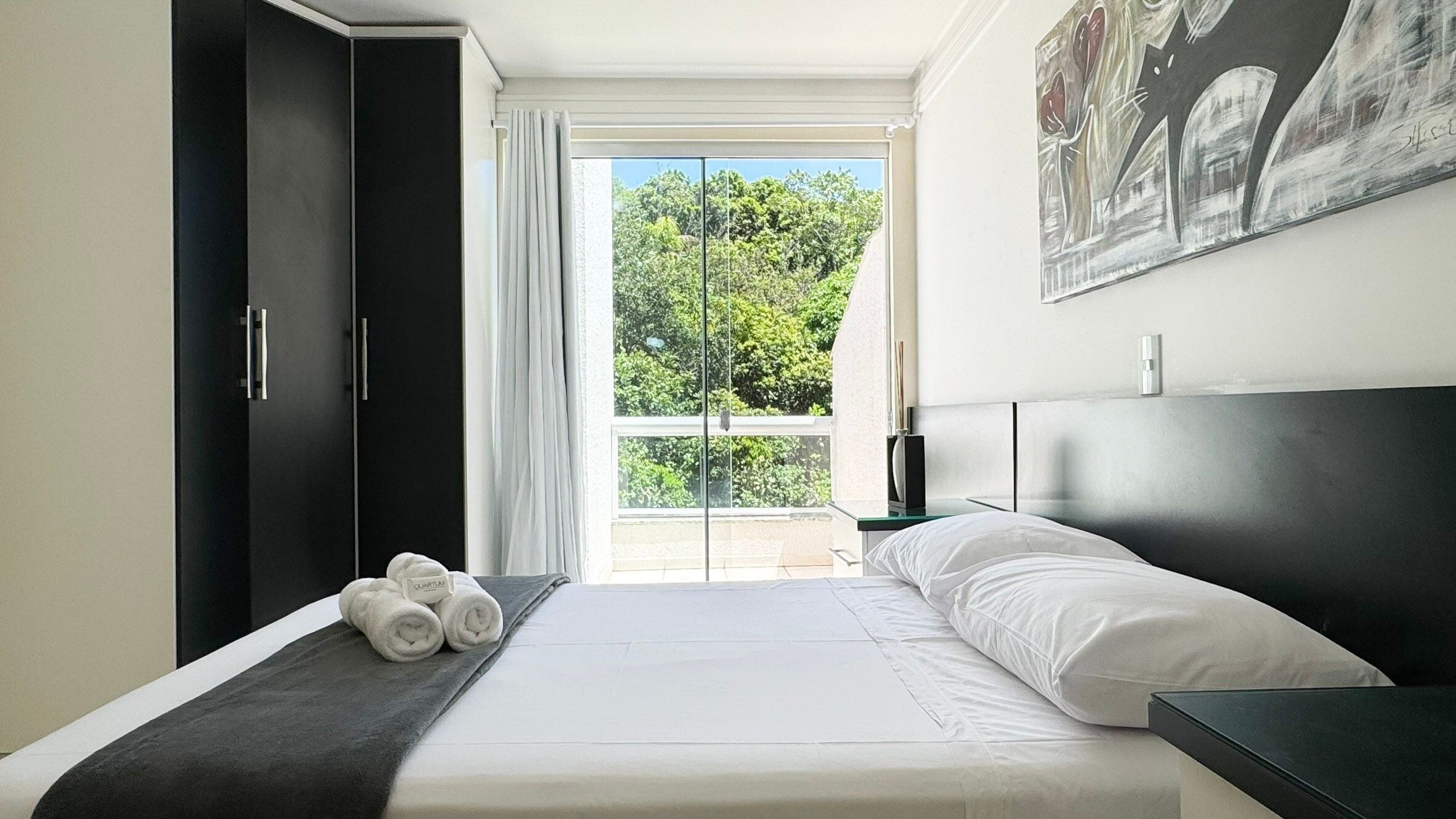 Um quarto moderno com uma cama grande, um guarda-roupa e um quadro na parede.