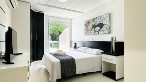 Une chambre à coucher moderne avec un lit, une table de chevet et un tableau au mur.