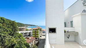 Ein modernes Gebäude mit weißer Fassade, einem kleinen Fenster mit Meerblick und einem Fliesenboden.