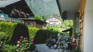 A courtyard with a stone pathway, potted plants, and a wooden bench. - Chalet Carina next ski slope (Zell am See)