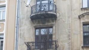 A building with a balcony, a window, and a car parked in front. - Cracow Route #4 - Old Town (Kraków)