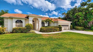 A single-story house with a red-tiled roof, a covered front porch, and a well-maintained lawn. - Private Pool, Pond Views, & Bonus Lounge in Gated Naples Community Drive to Dining & Sand (Naples)