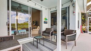 A covered patio with a pool, sliding glass doors, and outdoor seating. - Private Pool, Pond Views, & Bonus Lounge in Gated Naples Community Drive to Dining & Sand (Naples)