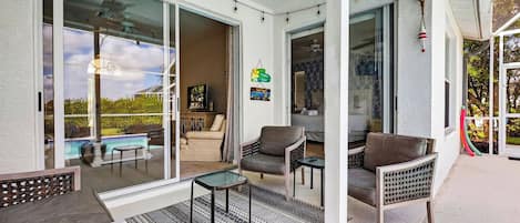 A covered patio with a pool, sliding glass doors, and outdoor seating.