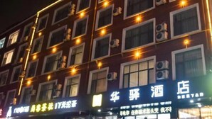 A hotel facade with multiple windows, some with lights on, and signage in a foreign language. - Home Inn Huayi (Linyi Lanling Yucai Road) (Lanling)