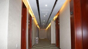 A hotel hallway with carpeted floors, wooden doors, and recessed lighting. - Home Inn Huayi (Linyi Lanling Yucai Road) (Lanling)