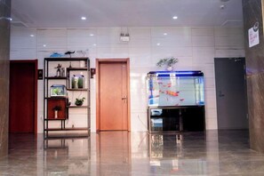Eine Lobby mit einem Aquarium, einer Holztür und einem Regal mit Dekoration.