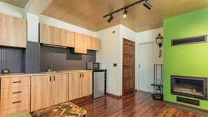 A modern kitchen with wooden cabinets, a microwave, and a built-in oven. - Warm Getaway 24/7 Power in Kfardebian (Jabal Lubnan)