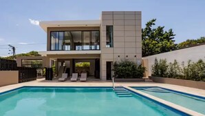 A modern two-story house with a swimming pool.