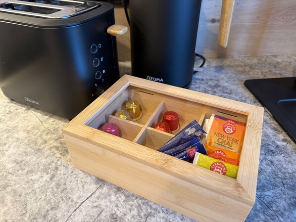 A wooden box containing various items on a kitchen counter. - Flussperle Miesbach | Dream Apartment with River Views and a Rooftop Terrace (Miesbach)