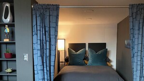 Une chambre à coucher moderne avec un lit, un canapé en cuir et une table de chevet avec une lampe.