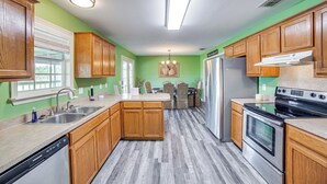 Una cocina con armarios de madera, lavavajillas, refrigerador y estufa.