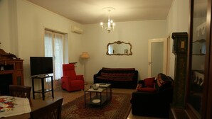 Una sala de estar con sofá, sillón, mesa de centro, televisor y chimenea.