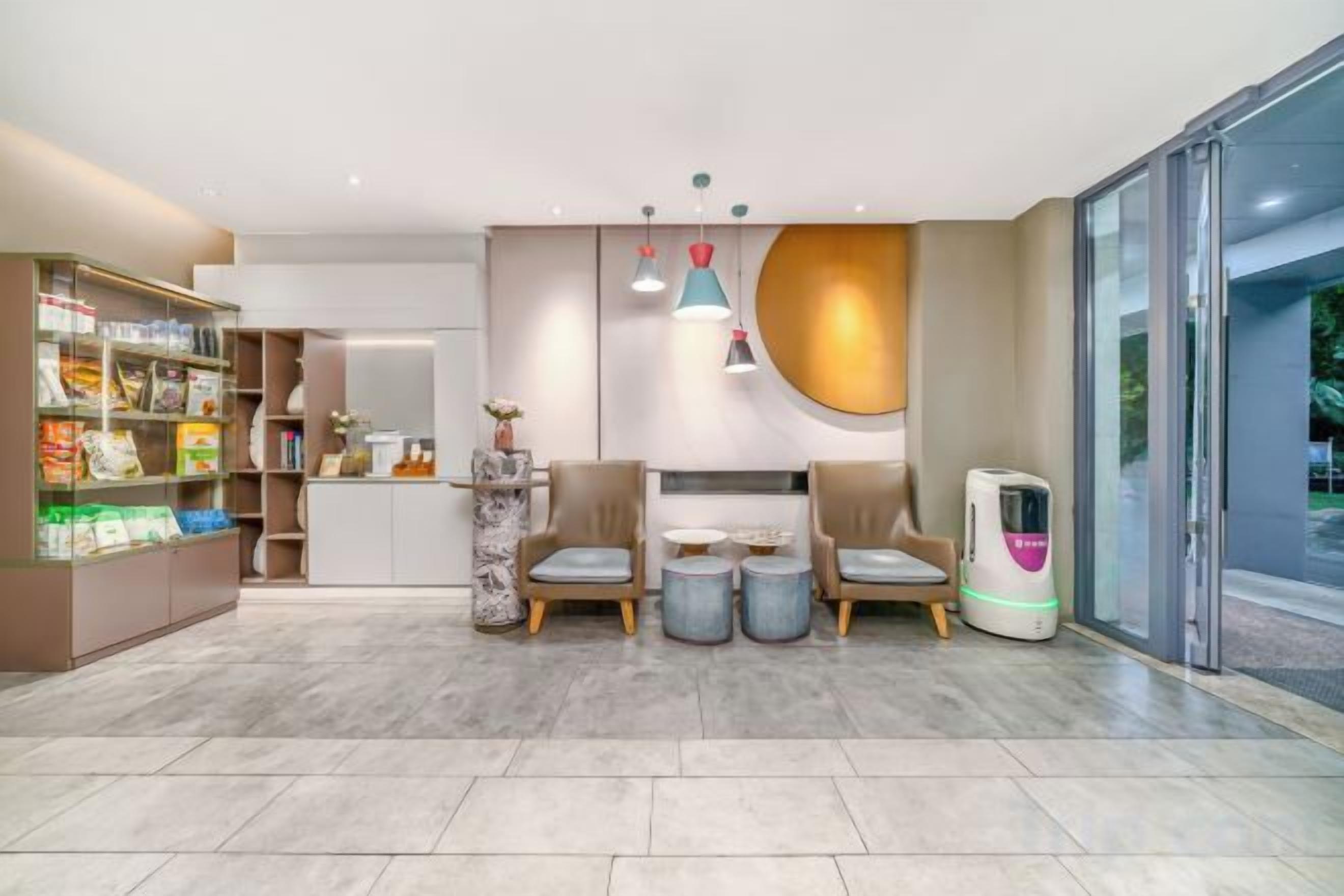 A modern interior with a reception desk, seating area, and a self-service kiosk.