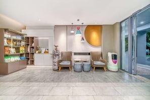 A modern interior with a reception desk, seating area, and a self-service kiosk. - Homeinn · neo (Haikou Qilou Old Street Donghu Road) (Haikou)