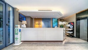A reception area with a modern design, a reception desk, a digital display, and a reception counter. - Homeinn · neo (Haikou Qilou Old Street Donghu Road) (Haikou)