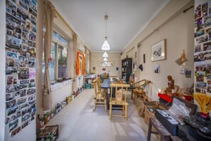 A cozy dining area with a wooden table and chairs, a hanging light fixture, and a wall adorned with photographs. - Kehuayuan Hotel (Chengdu Huaxie) (Chengdu)