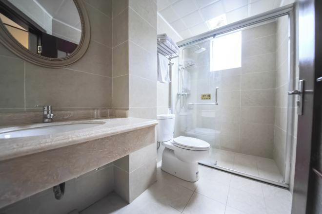A bathroom with a sink, toilet, and glass-enclosed shower.