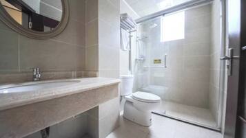 A bathroom with a sink, toilet, and glass-enclosed shower.