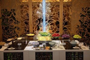 A buffet with various food items and a decorative light fixture. - Yayuncun Hotel (Beijing)