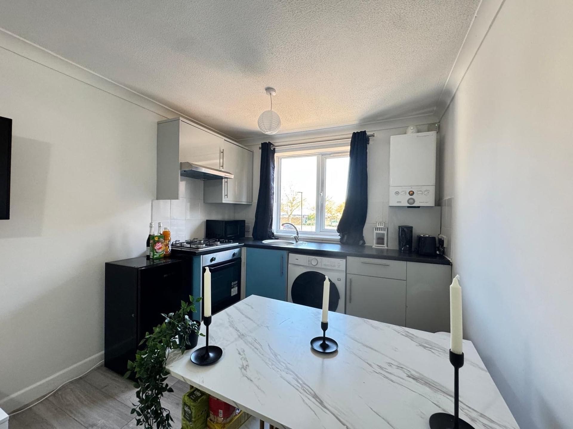 A compact kitchen with a gas stove, a sink, and a dishwasher.