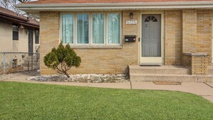 Une maison de plain-pied avec une façade en briques, une porte d’entrée et une boîte aux lettres.
