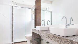 Ein modernes Badezimmer mit Duschkabine aus Glas, Toilette und doppelter Waschtisch.