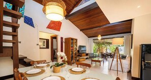 Un coin repas avec une table blanche dressée pour quatre personnes, entourée de chaises en bois.