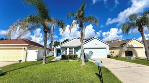 A residential area with houses, a well-maintained lawn, and a clear sky.