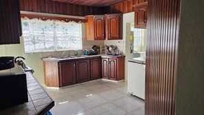 Una cocina con armarios de madera, un fregadero, una estufa y un refrigerador.