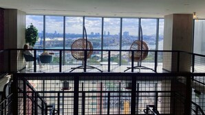 A spacious balcony with a city view, featuring a modern railing and two wicker chairs. - Miami Downtown 27 floor Luxe Escape rooftop pool and jacuzzi (Miami)