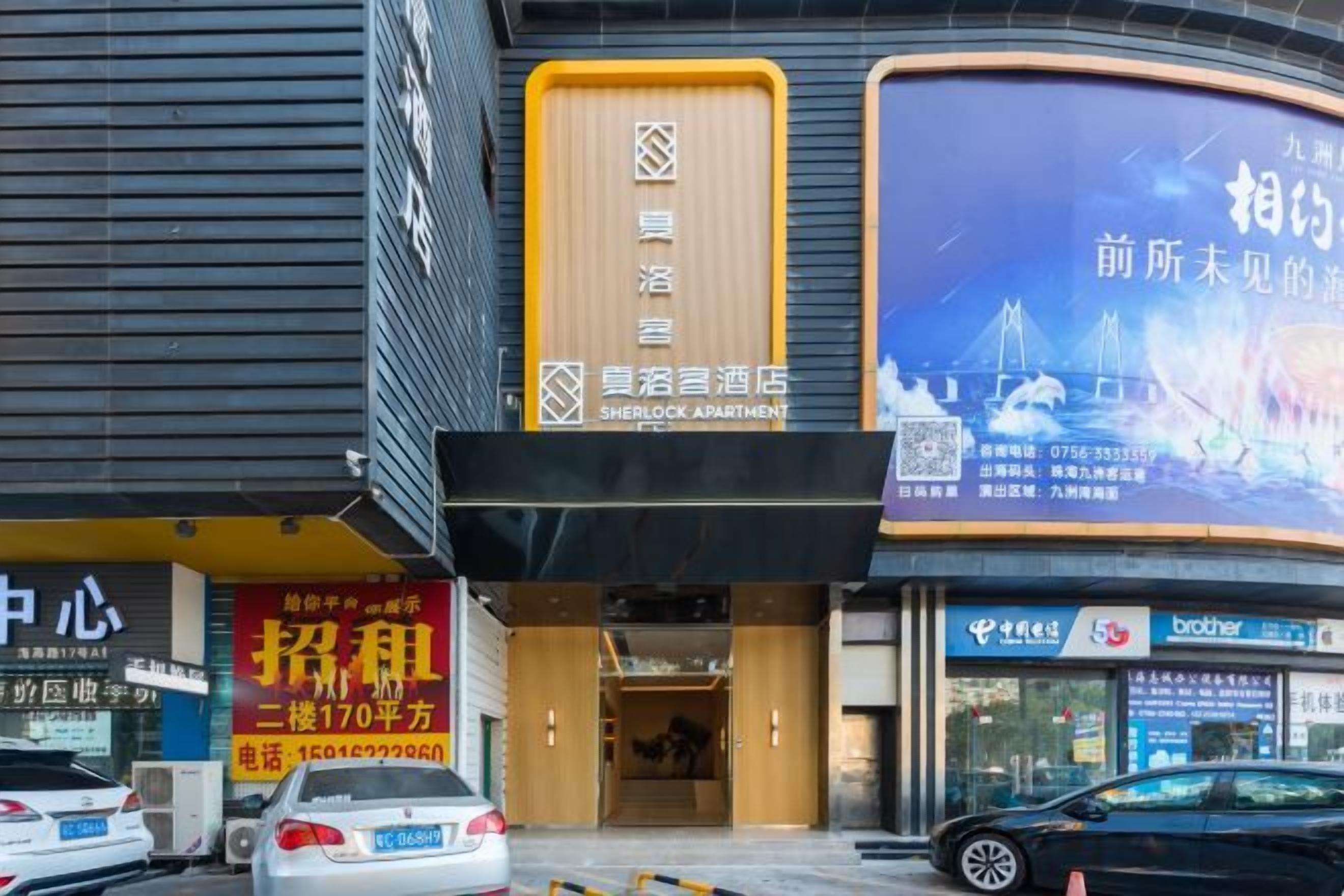 Un hotel con un cartel que indica Sherlock Apartment, una entrada visible y un escaparate con un electrodoméstico de la marca Brother.