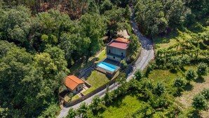 An aerial view of a property with a swimming pool, a stone house, and a vineyard. - Casa do Penedo - Aqua View (Vila Verde)