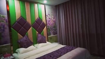 Quarto de hotel com uma cama, mesa de cabeceira, parede com painel decorativo e janela com cortinas.