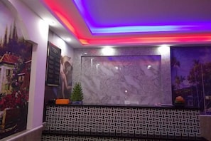 A reception area with a marble wall, patterned wall design, and a framed picture. - Shule Hostel (Shanghai)