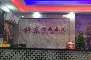 A hotel reception desk with a marble wall and a sign in a foreign language. - Shule Hostel (Shanghai)