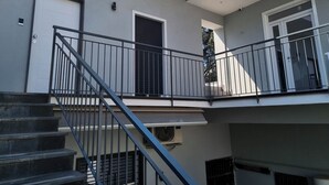 Un immeuble résidentiel à plusieurs niveaux, doté d’un escalier, de balcons et d’une verrière.