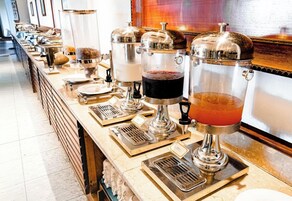 Una barra de buffet con diferentes dispensadores de comida y bebida.