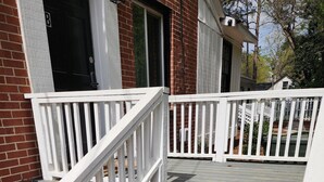 A wooden staircase with white railings leading to a porch. - Kenan Cottage in Whirlygig City, Unit B - 3 bd, 2 ba- 1300sf  - Downtown Wilson (Wilson)